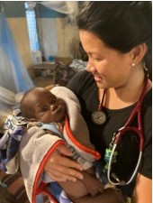 Pediatrician Lye-Ching gets a cuddle from little Jikany
